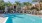 a pool with chairs and umbrellas by apartment building