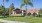 clubhouse with a palm tree and a lawn in front of it